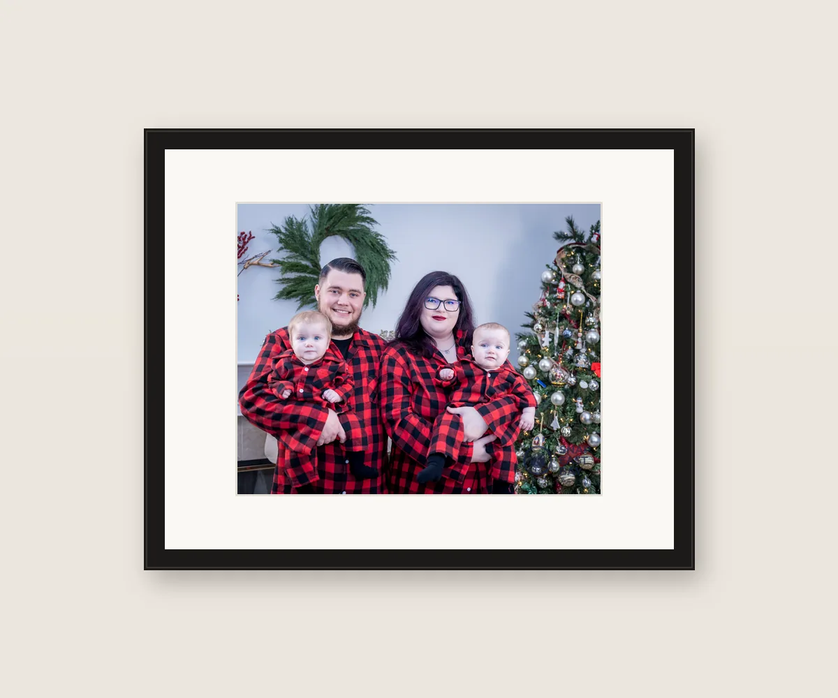 Framed 8x10 of a family in matching red flannel by the Christmas tree